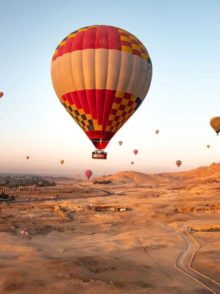 Hot-air balloons drifting over the West Bank of Luxor at dawn