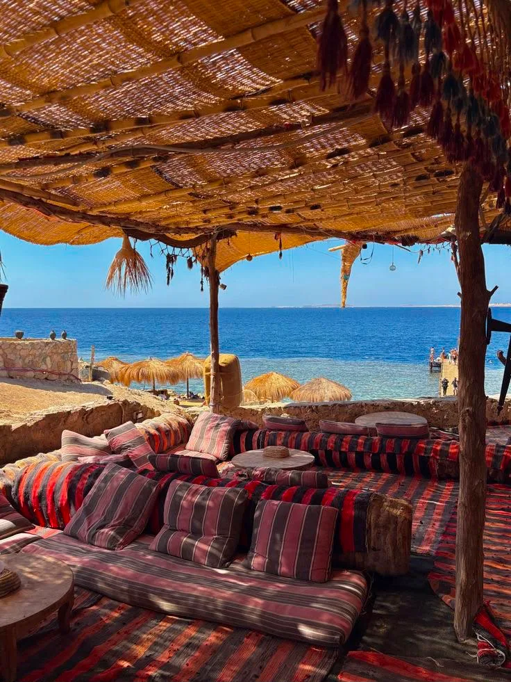 A carved cliffside lounge above the Red Sea at sunset near Sharm El Sheikh